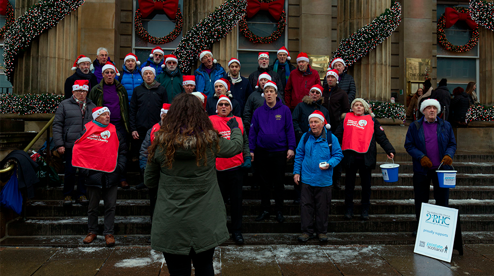 Cheerful group of people gathered on a staircase to perform a Christmas carol